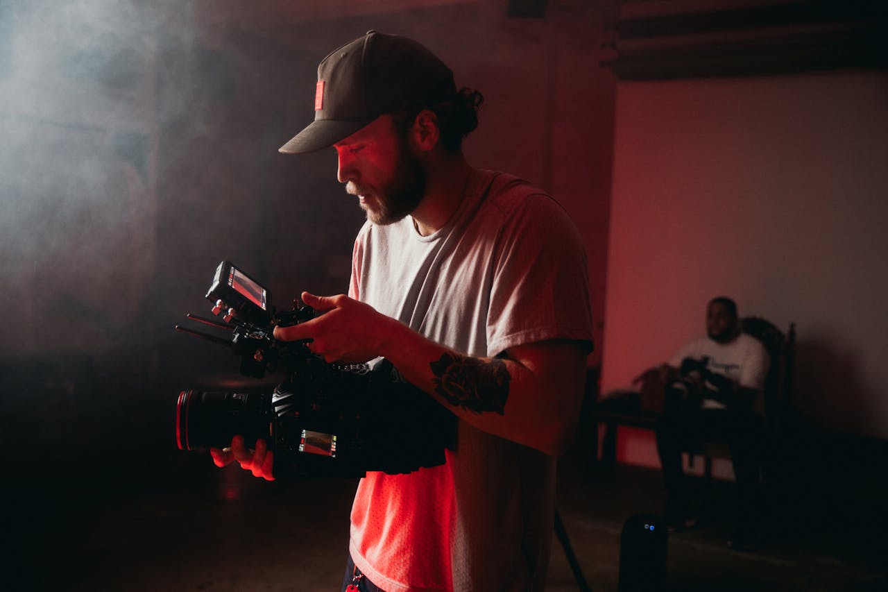 about-07 Professional cinematographer operating a camera indoors with dramatic lighting.